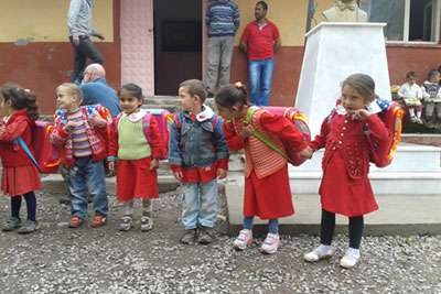 Kinder tragen die gespendeten Schulranzen